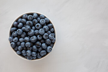 Organic Blueberries in a Bowl on a gray background, top view. Flat lay, overhead, from above. Copy space.