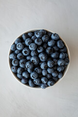Organic Blueberries in a Bowl on a gray background, top view. Flat lay, overhead, from above.