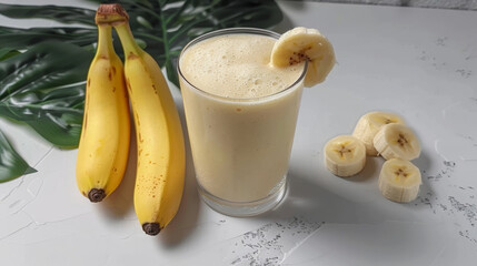 liquid banana smoothie in a glass, on wooden board with bananas, on white background