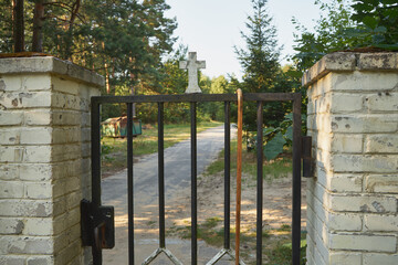 drewniana laska powieszona na cmentarnej bramie  © Marcin Łazarczyk