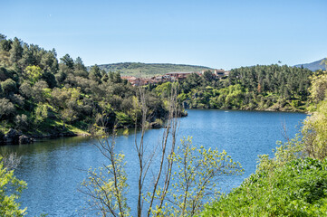 Fototapeta premium View of the Lozoya river surrounded by hills and vegetation 