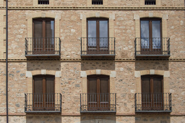 six equal balconies on a stone facade in a building in Soria. Spain	
