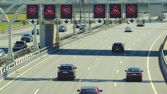 Flow of cars on highway expressway with signs speed limit 90 kilometers per hour, traffic jam rush hour and windy weather