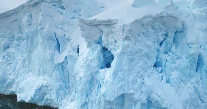 Global Warming and Climate Change - Giant glacier towers in Antarctica. Aerial drone view arctic nature winter landscape. Melting ice floes fjord in cold polar ocean. Global issue of melting icebergs