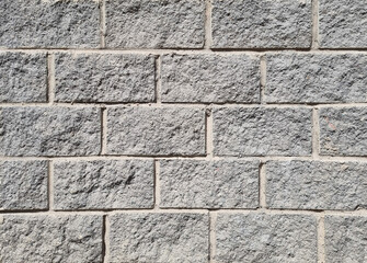 Granite  surface texture, background. The wall is made of gray stone blocks.