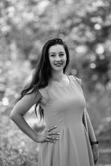 Portrait of a young beautiful dark-haired girl in nature in black and white style.