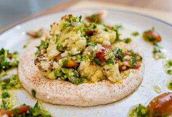 Tasty bean porridge with cauliflower and vegetables on white plate