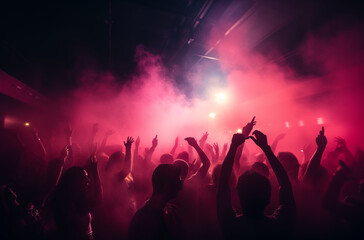 Large crowd of people dancing with raised hands in a nightclub filled with vibrant pink and purple lights and smoke