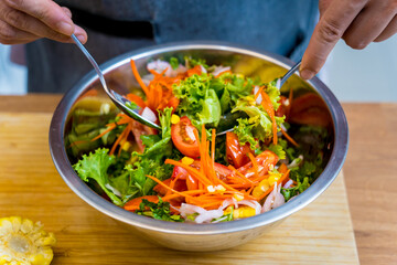 Chef at the kitchen preparing spicy glass noodle salad