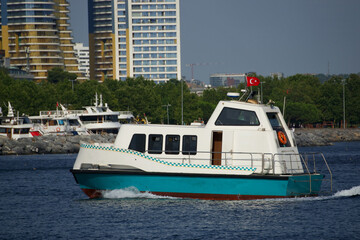 The sea taxi sails in the blue sea against the backdrop of modern Istanbul buildings
