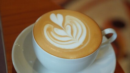 A white cup of coffee with latte art.