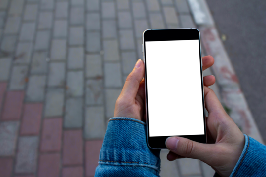 Hand holding blank screen smartphone at the outdoor, mockup phone, transparent background png