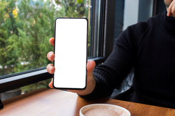 Hand holding blank screen smartphone at the cafe, mockup phone, transparent background png