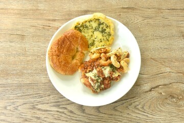 baking crispy butter croissant French bread butter garlic with macaroni dressing fried chop pork and slice tomato in ketchup sauce on plate  