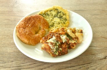 baking crispy butter croissant French bread butter garlic with macaroni dressing fried chop pork and slice tomato in ketchup sauce on plate  