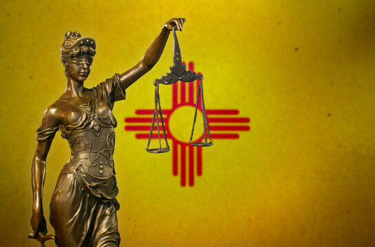 Lady Justice before a flag of New Mexico