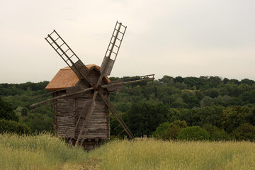 Fototapeta premium Old wooden windmill in green field