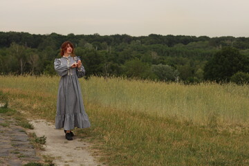Pretty brunette woman in vintage dress walking by brick road