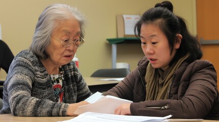 Volunteer helps an elderly person with their paperwork at a community center They sit together at a table, the volunteer explaining forms with clarity and care