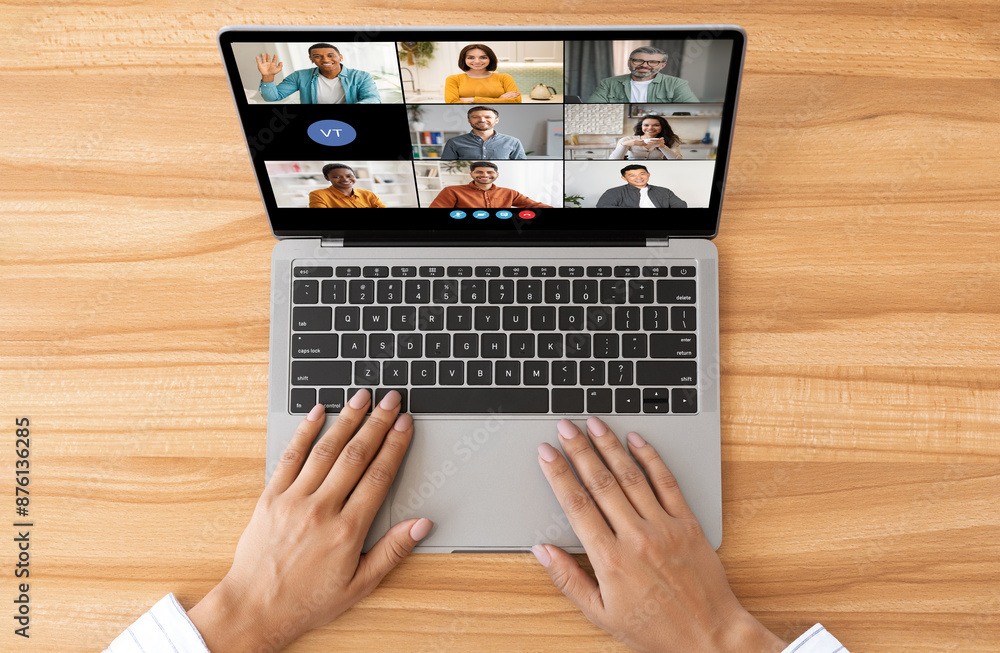 Poster a top-down view of a persons hands using a laptop for a video conference. the laptop screen shows a 