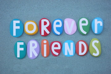 Forever friends, social creative slogan composed with hand painted multi colored stone letters over...