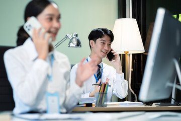 Business man and business woman sitting on desk using Tablet and laptop, working environment. Happy businessteam in casual working on computer in office.