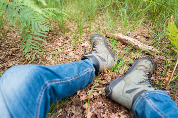 Hiker seen resting on the soft pine forest floor while out for a long hike in an English forest. Seen resting part way on a long, forest hike.