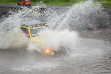 The jeep crashed into the river, blurry water spurting out