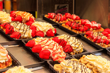 Belgian waffles with colorful sweet toppings and fruits for sale in Brussels, Belgium