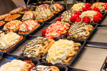 Belgian waffles with colorful sweet toppings and fruits for sale in Brussels, Belgium