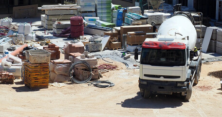 Busy Construction Site with Cement Mixer Truck and Building Materials