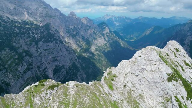 An awe-inspiring aerial view of the Slovenian Alps, featuring the majestic peaks of Vi&scaron;evnik, Jezerca, and Veliki Dra&scaron;ki vrh. These stunning mountains offer breathtaking hiking trails