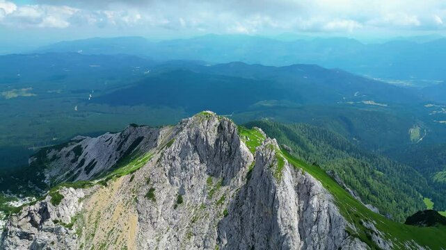 An awe-inspiring aerial view of the Slovenian Alps, featuring the majestic peaks of Vi&scaron;evnik, Jezerca, and Veliki Dra&scaron;ki vrh. These stunning mountains offer breathtaking hiking trails