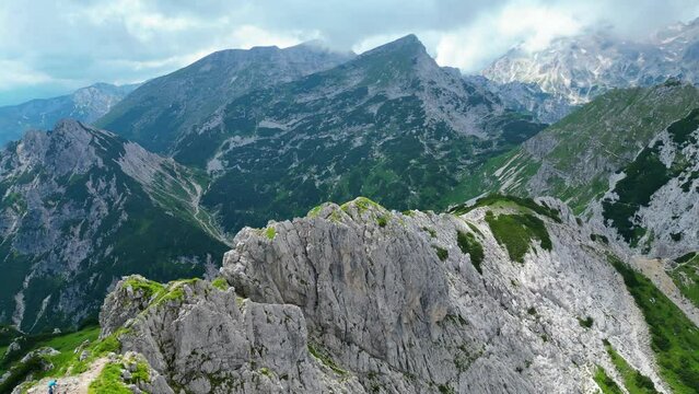 An awe-inspiring aerial view of the Slovenian Alps, featuring the majestic peaks of Vi&scaron;evnik, Jezerca, and Veliki Dra&scaron;ki vrh. These stunning mountains offer breathtaking hiking trails