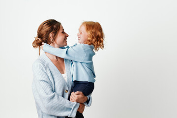 Mother and daughter embracing in front of white background, love and careful bonding concept