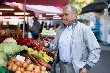 Man choosing carrots in market