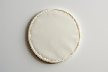 pristine white circular embroidered patch floating on neutral background blank canvas for design with detailed stitching along the edges creating a tactile threedimensional effect