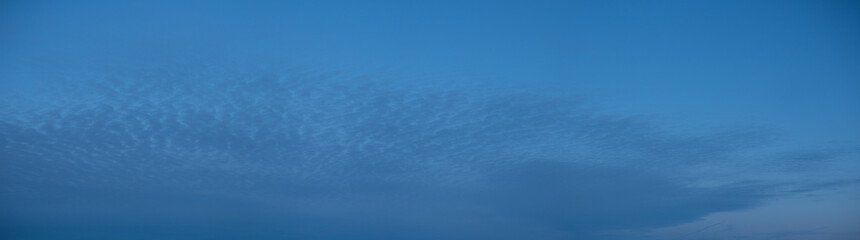 High stationary clouds and lower clouds, moving across the night sky,