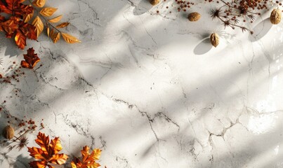 Top view of a smooth pale grey countertop, frame of autumn leaves and nuts