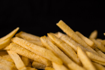 Mountain of fries close-up on dark background. Macro 