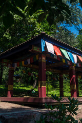 Obraz premium Buddhist building in the park. Asian building in the park with flags of different colors on the roof