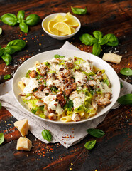 Chicken Caesar Pasta Salad with sauce in white plate. Healthy food.