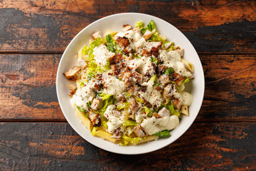 Chicken Caesar Pasta Salad with sauce in white plate. Healthy food.