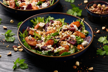 Warm baked carrots and beetroot salad with feta cheese and roasted hazelnuts