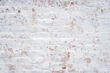 Plaster texture. Peeling plaster on an old brick wall