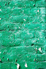 Plaster texture. Peeling green paint on a plastered old brick wall