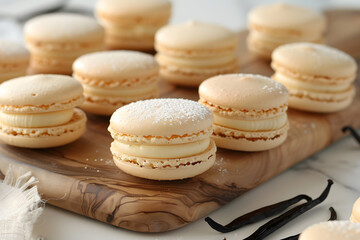 Fototapeta premium Gourmet vanilla macarons with smooth creamy filling on rustic wooden serving board, close-up.