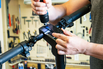 Repairing an electric scooter in a workshop. A close-up shot of a master disassembling a scooter...