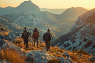 Obraz premium Group of Hikers Trekking Through Mountainous Terrain at Sunrise with Scenic Views and Golden Light