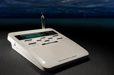 Lighting and clouds approaching a weather radio with hurricane warning